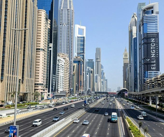Dubai skyline along Sheikh Zayed Road showing multi-lane traffic, modern skyscrapers, and urban transport infrastructure in the UAE.