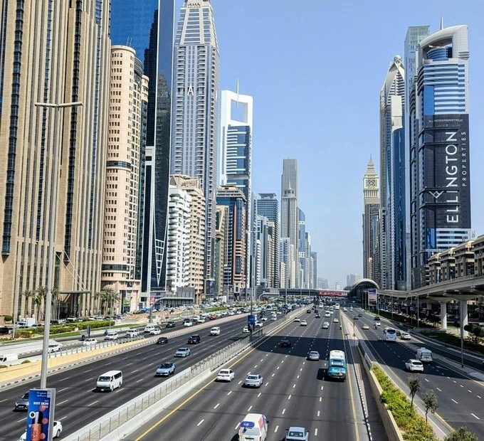 Dubai skyline along Sheikh Zayed Road showing multi-lane traffic, modern skyscrapers, and urban transport infrastructure in the UAE.