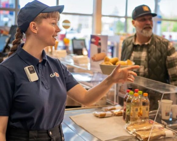 Axis W111 body worn camera worn by a retail employee assisting a customer