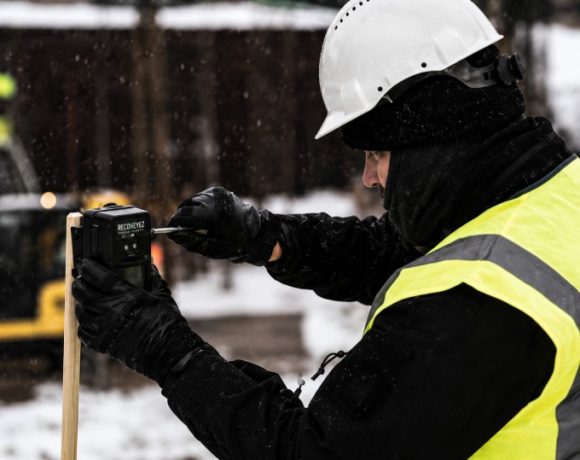 Worker installing a Reconeyez wireless security sensor at a construction site