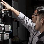 Technicians inspecting a physical access control controller panel